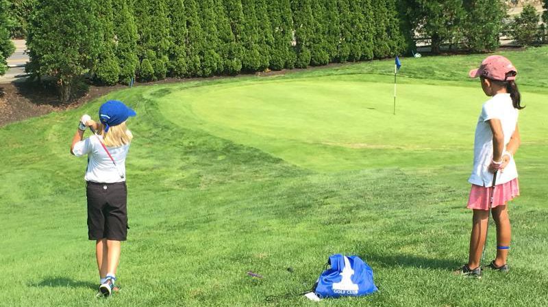 Junior golfers practicing golf swing