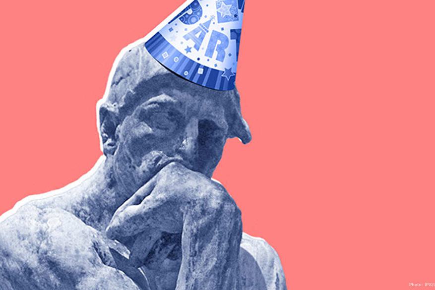 The Thinker sculpture wearing a party hat