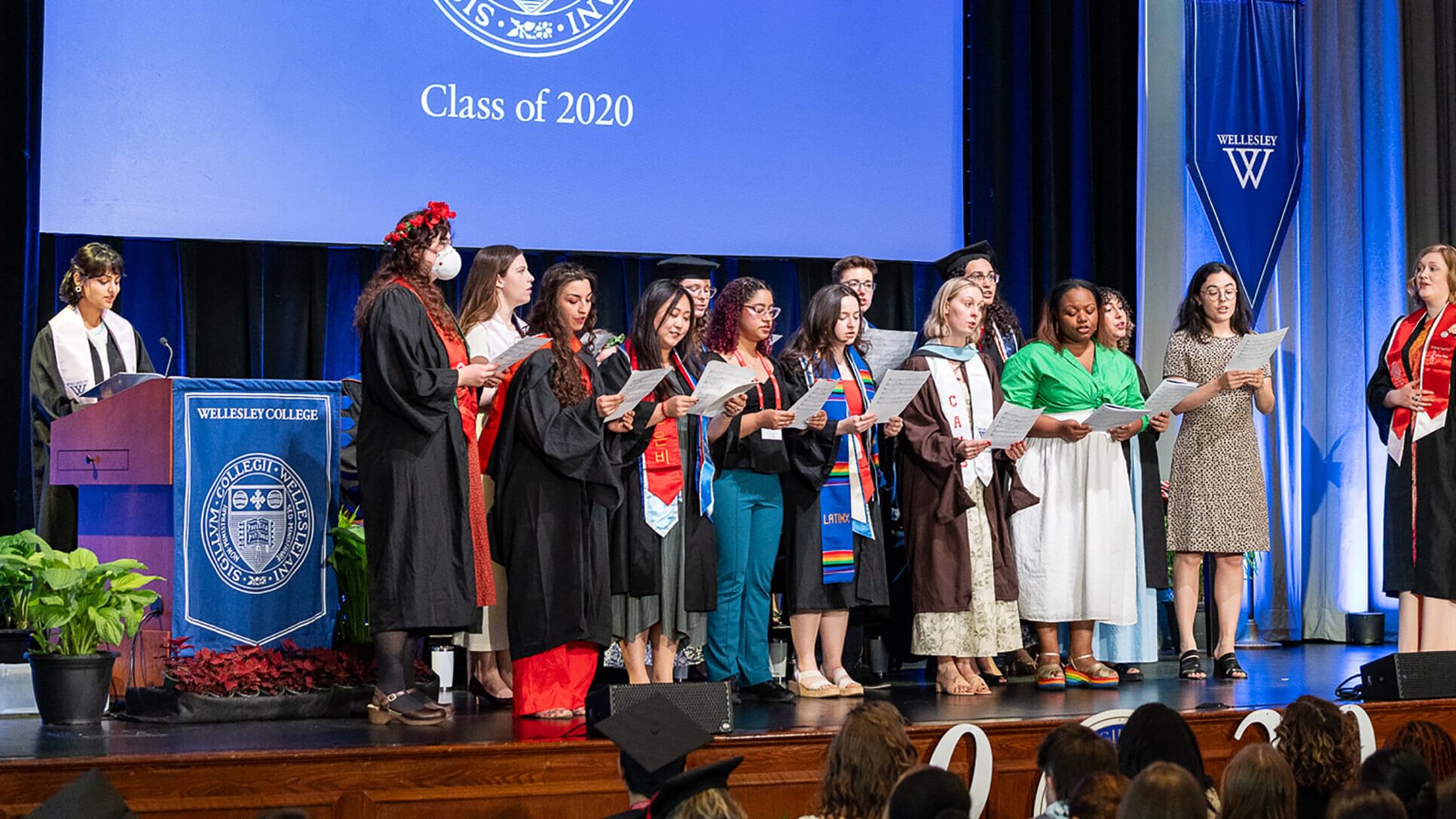 Members of the 2020 chorus sing on stage.