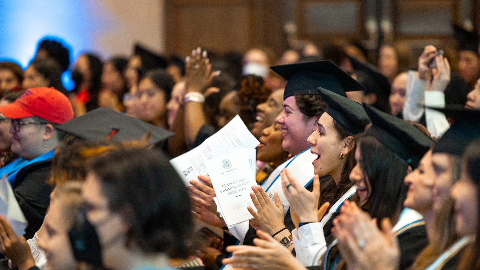 Class of 2020 applaud and smile from the audience.