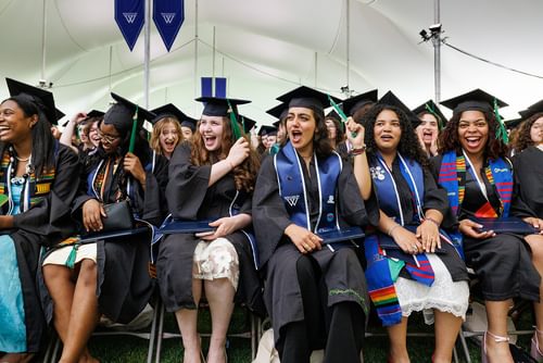 Graduates cheer and laugh as they flip the tassels on their mortarboard.