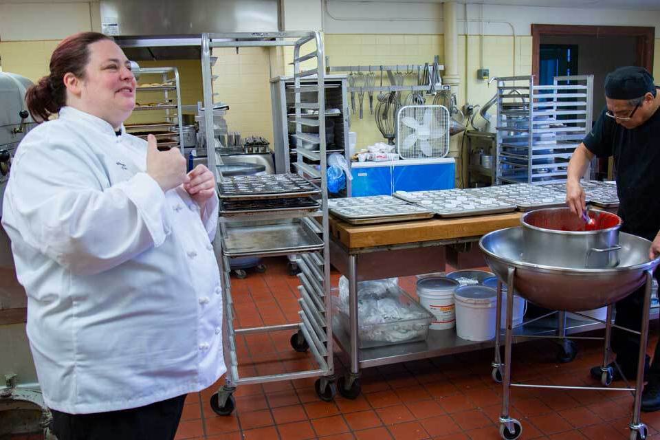 Manager Lori Davidson and baker Jesus Reyes prepare cupcakes for the oven