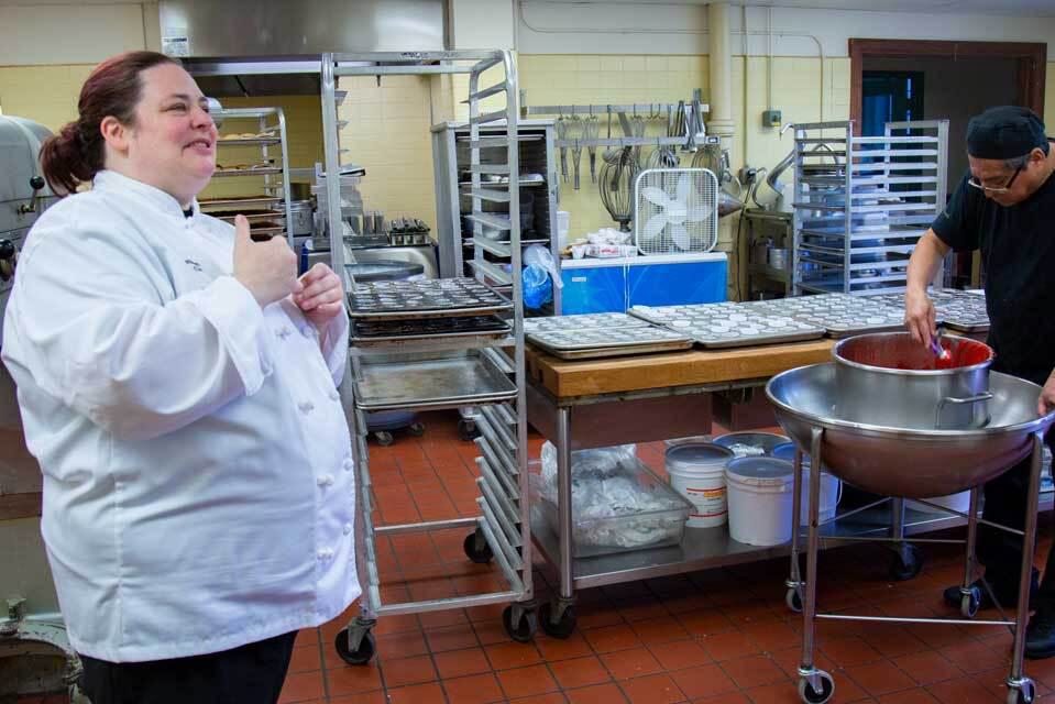 Manager Lori Davidson and baker Jesus Reyes prepare cupcakes for the oven