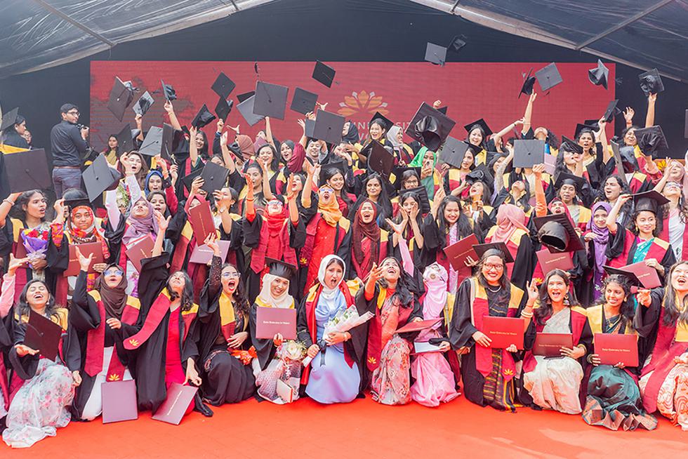 Graduate from Asian University for Women throw up their mortar boards to celebrate their graduation.