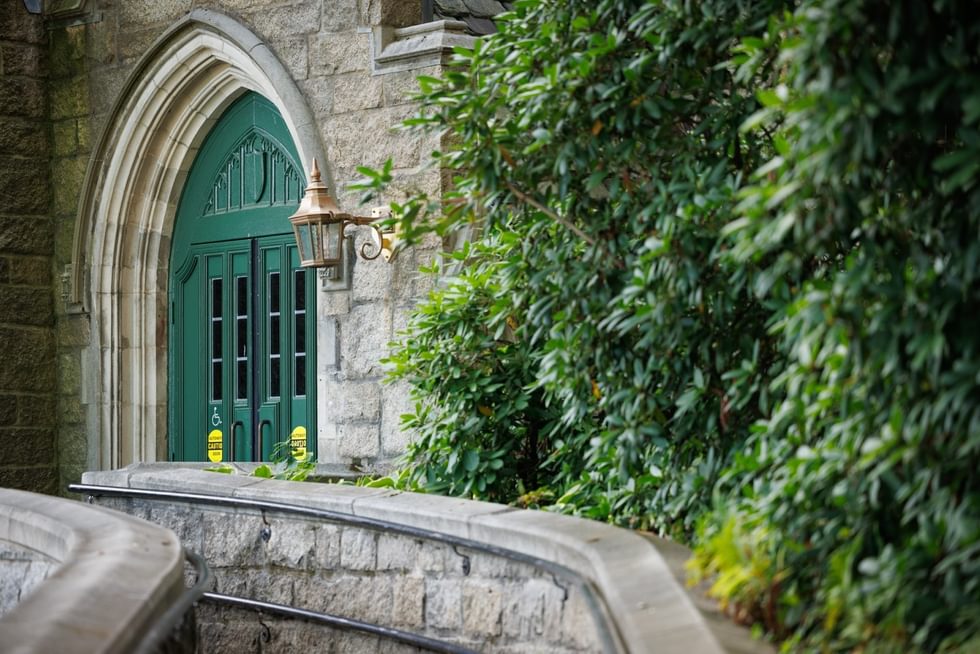 Green door to Founders Hall flanked by greenery