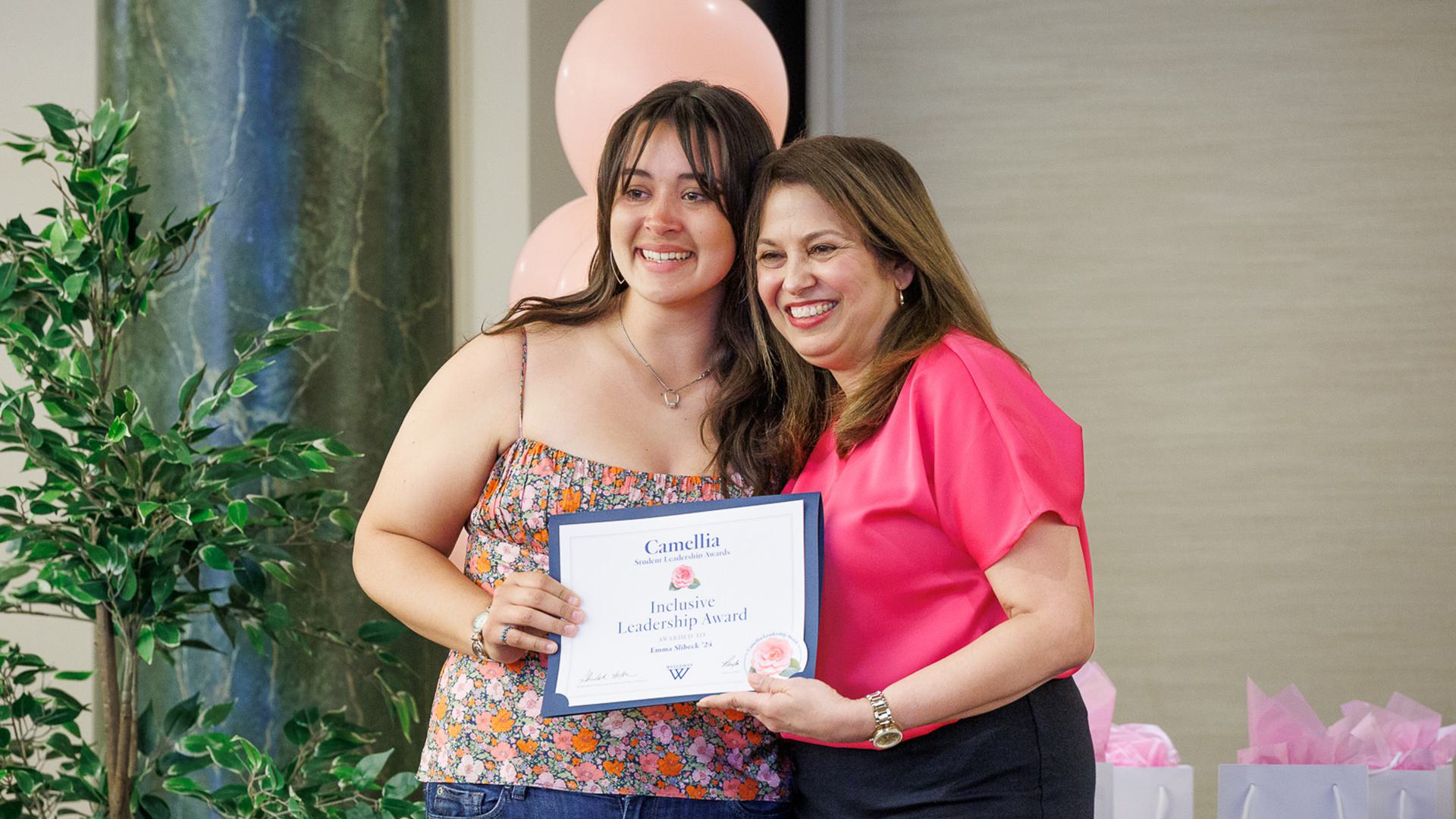 Emma Slibeck and Mared Alicea-Westort pose for a photo from the stage.