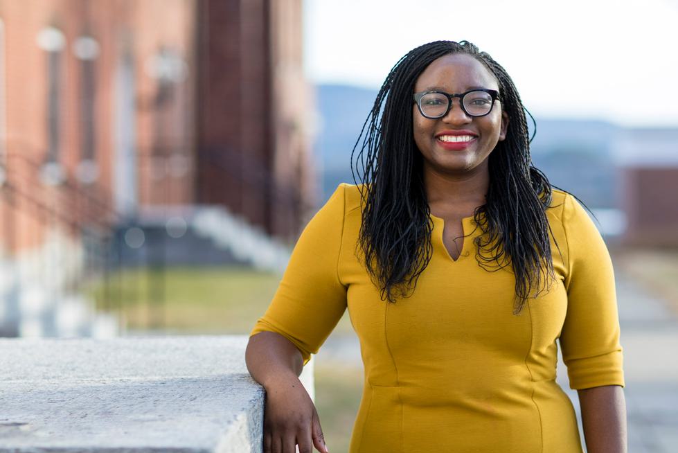 Portrait of Professor Chipo Dendere, standing outside on campus, looking at camera and smiling.