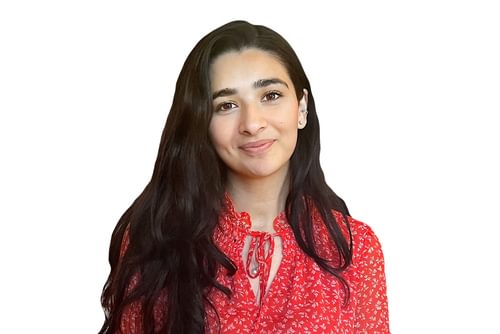 Headshot of Eshika Kaul against a white background. She wears a red top and has long dark hair