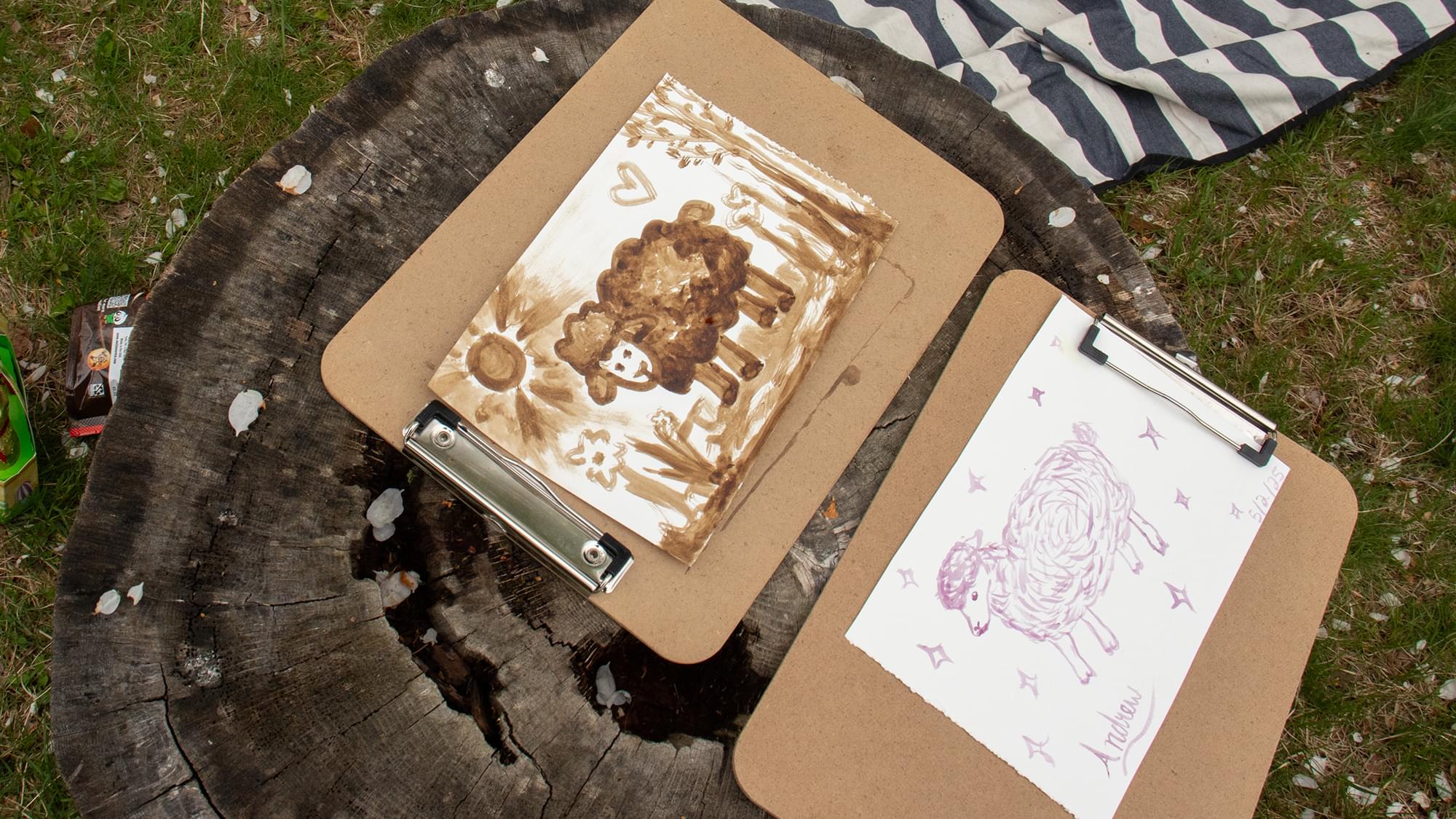 Two drawings of sheep rest on a tree stump.