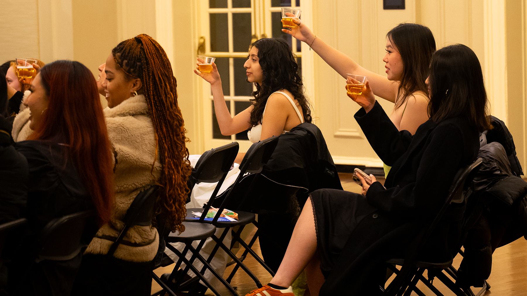 Students toast the seniors with glasses of sparkling grape juice.