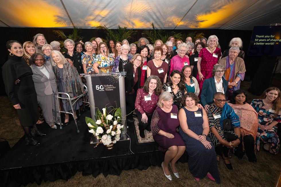 A large group of Wellesley Centers for Women staff—past and present—gathered on stage for a photo.
