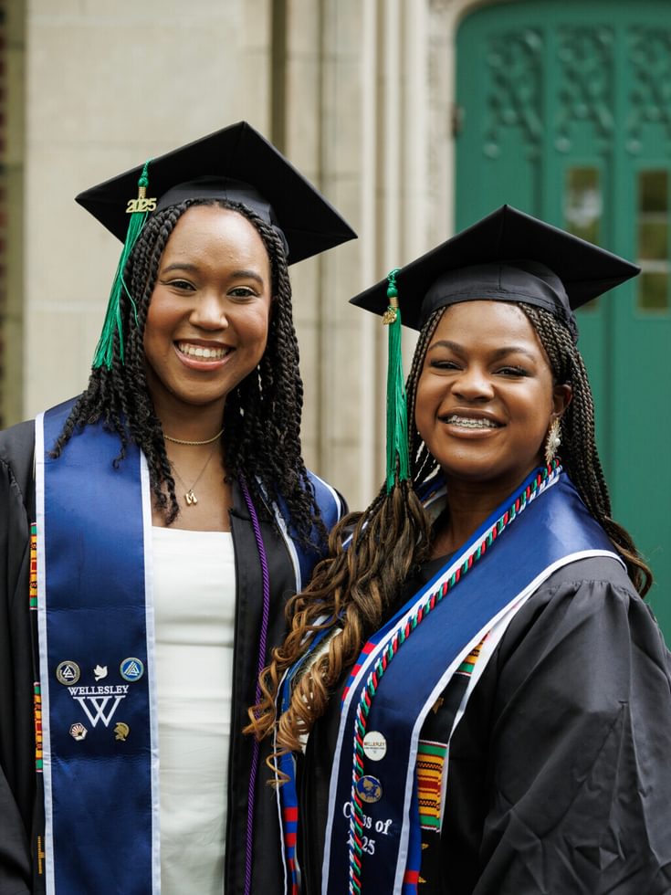 Two students pose in front of Green Hall for a photo.
