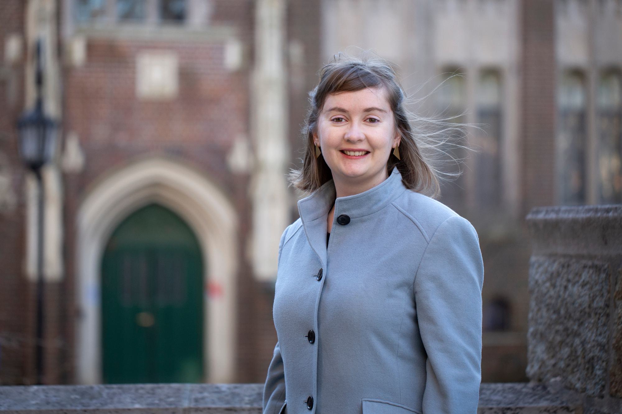 Woman stands outside in front of a building