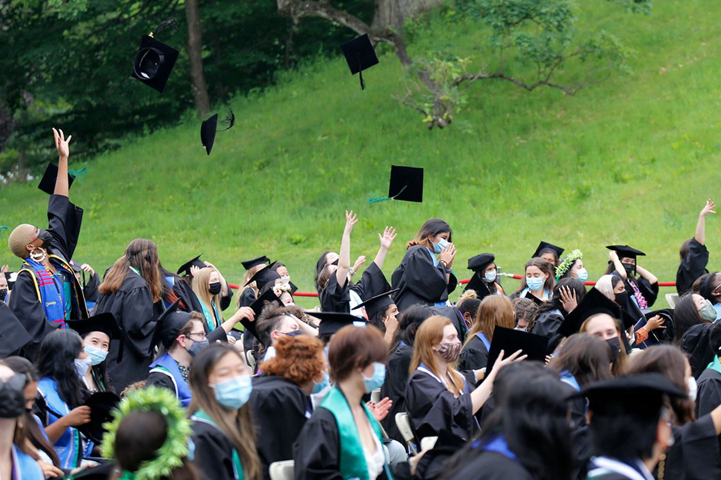 students tossing up their graduation caps