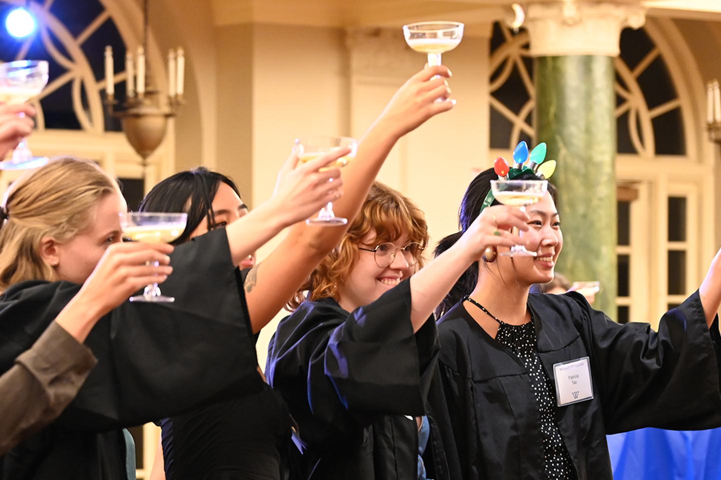 Students lift their glasses of sparkling juice in a toast.