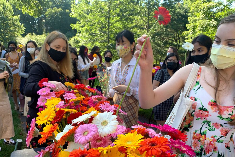 people picking up colorful flowers