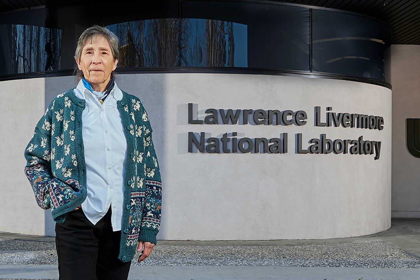 Judy Harte stands in front of Lawrence Livermore National Lab building.