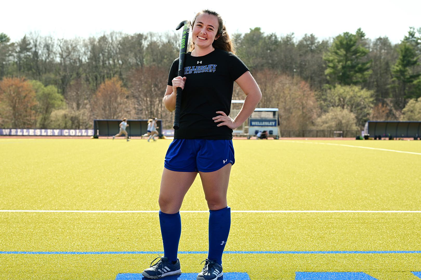 Lindsay Strong ’23 stands on field hockey field with stick over her shoulder