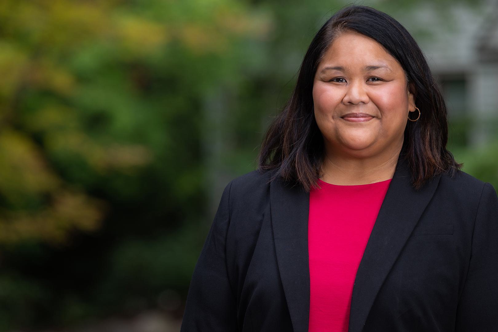 A portrait of Peaches Valdes. She wears pink top under a dark blazer.