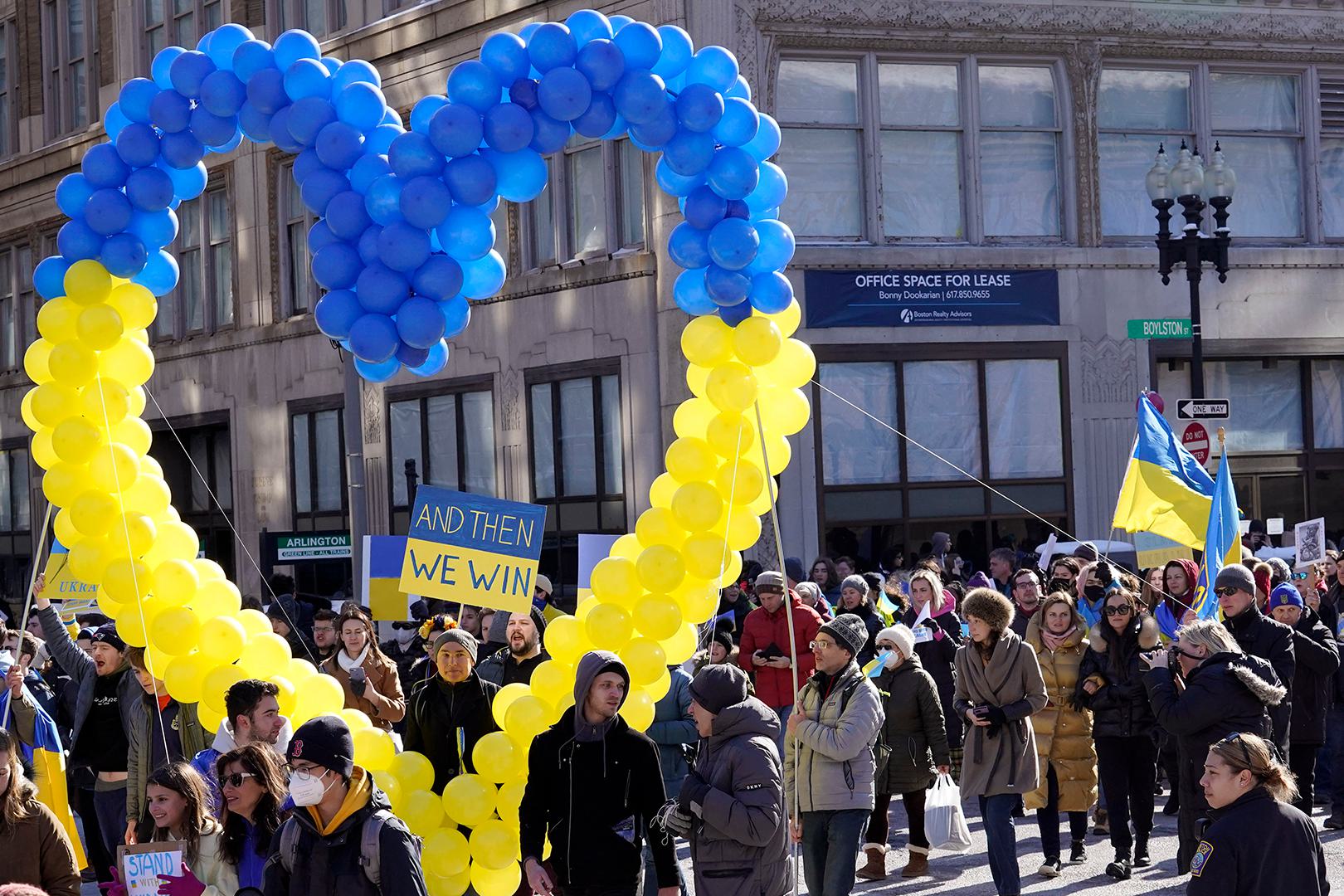 Demonstrators display a heart made of balloons featuring colors from the Ukrainian flag as they march during a rally in support