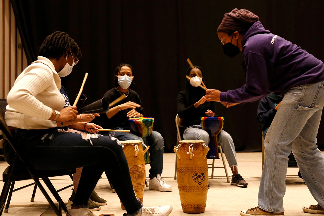 Kera Washington demonstrates drumming to students in Yanvalou.