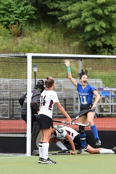 Wellesley College field hockey player, Arielle Mitropolis, celebrates with her teammates after scoring a goal.