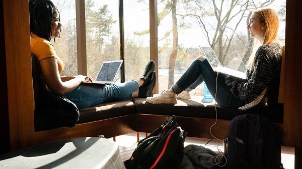 Two students sit with their laptops in the Lulu Chow Wang Campus Center