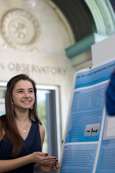 Wellesley College student stands next to her research poster
