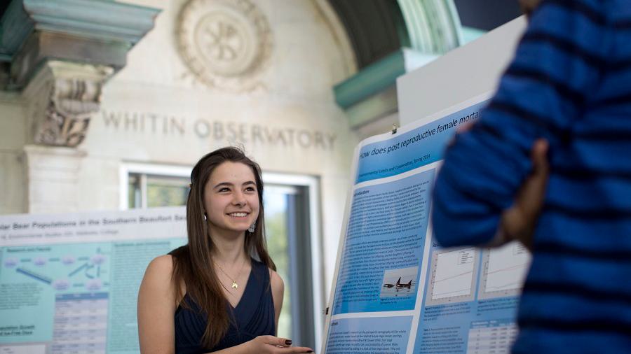 Wellesley College student stands next to her research poster