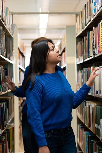 Two students browse for books in the Wellesley College Clapp Library