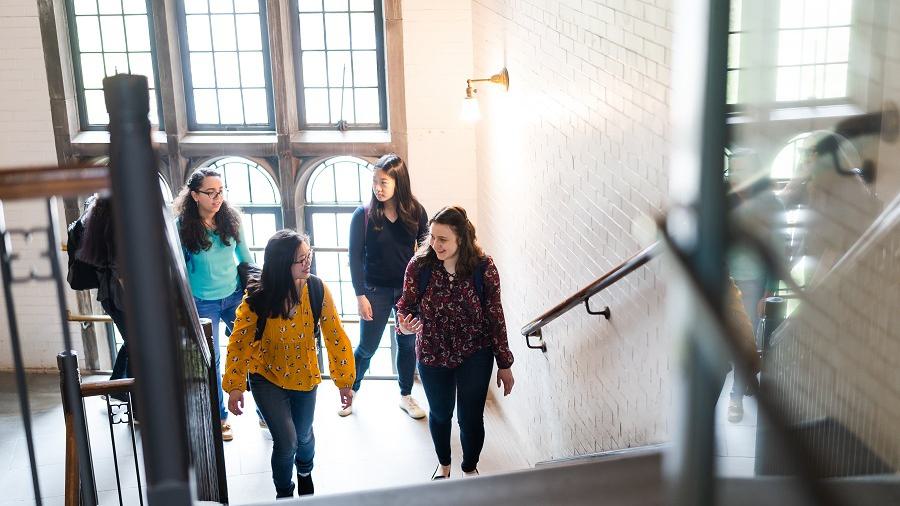 A group of students walk up a steps in Wellesley College's Green Hall