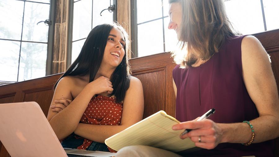 A Wellesley College student sits and talks with her professor