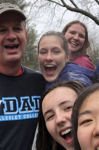 Wellesley College student, Lilly Armstrong, and a group of friends, pose fora photo cheering on Lilly's dad who is running the Boston Marathon