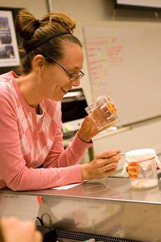 Wellesley College professor looks at sample in a lab science