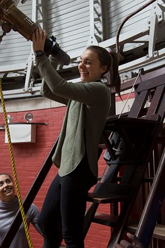 Wellesley students use a telescope in the Whitin Observatory