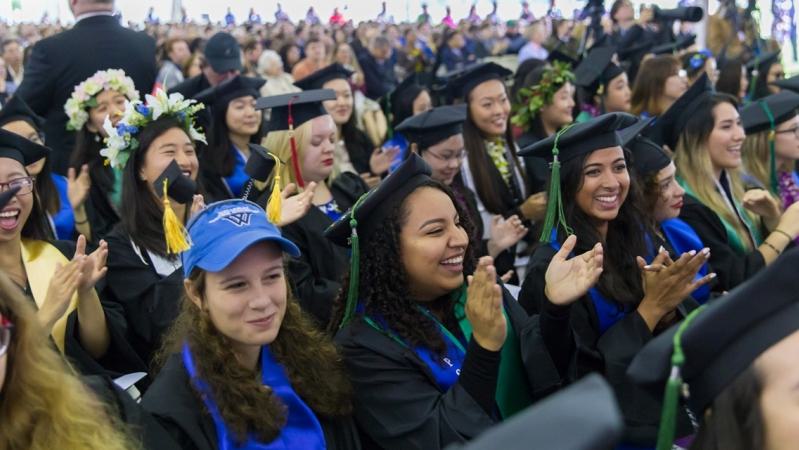 Seniors clap and cheer during graduation