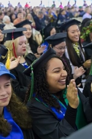 Seniors clap and cheer during graduation