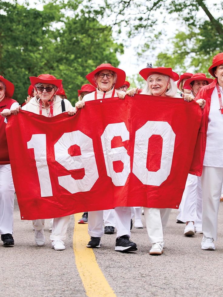 The class of 1960 marches behind their banner