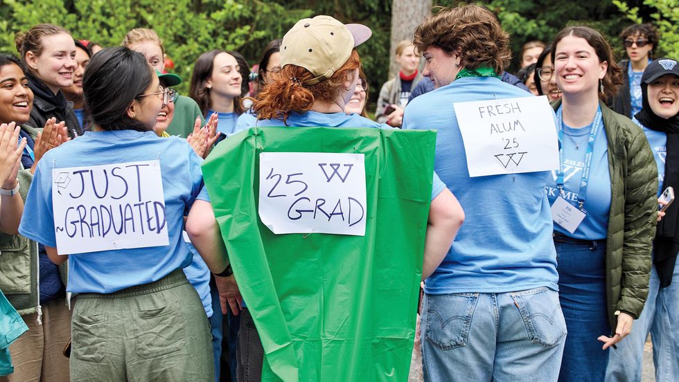 Three student workers in the class of 2025 wear signs saying "Just graduated," "Fresh Alum," and "Class of 2025"