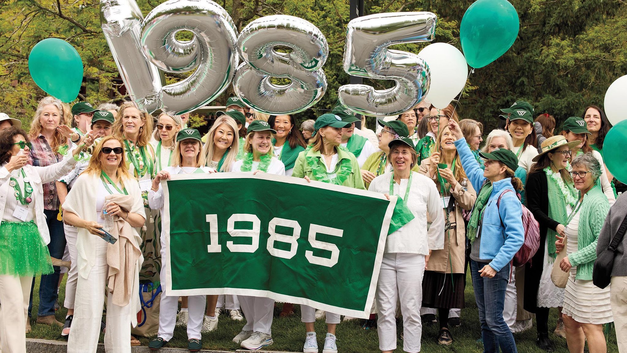 The class of 1985 wave behind their banner