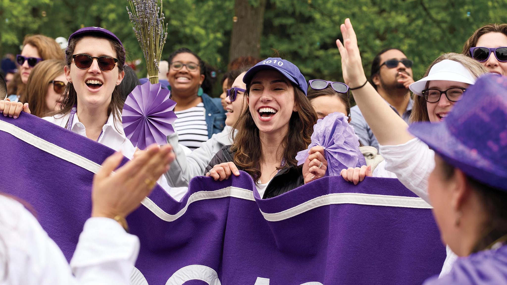 The class of 2010 cheer behind their purple banner